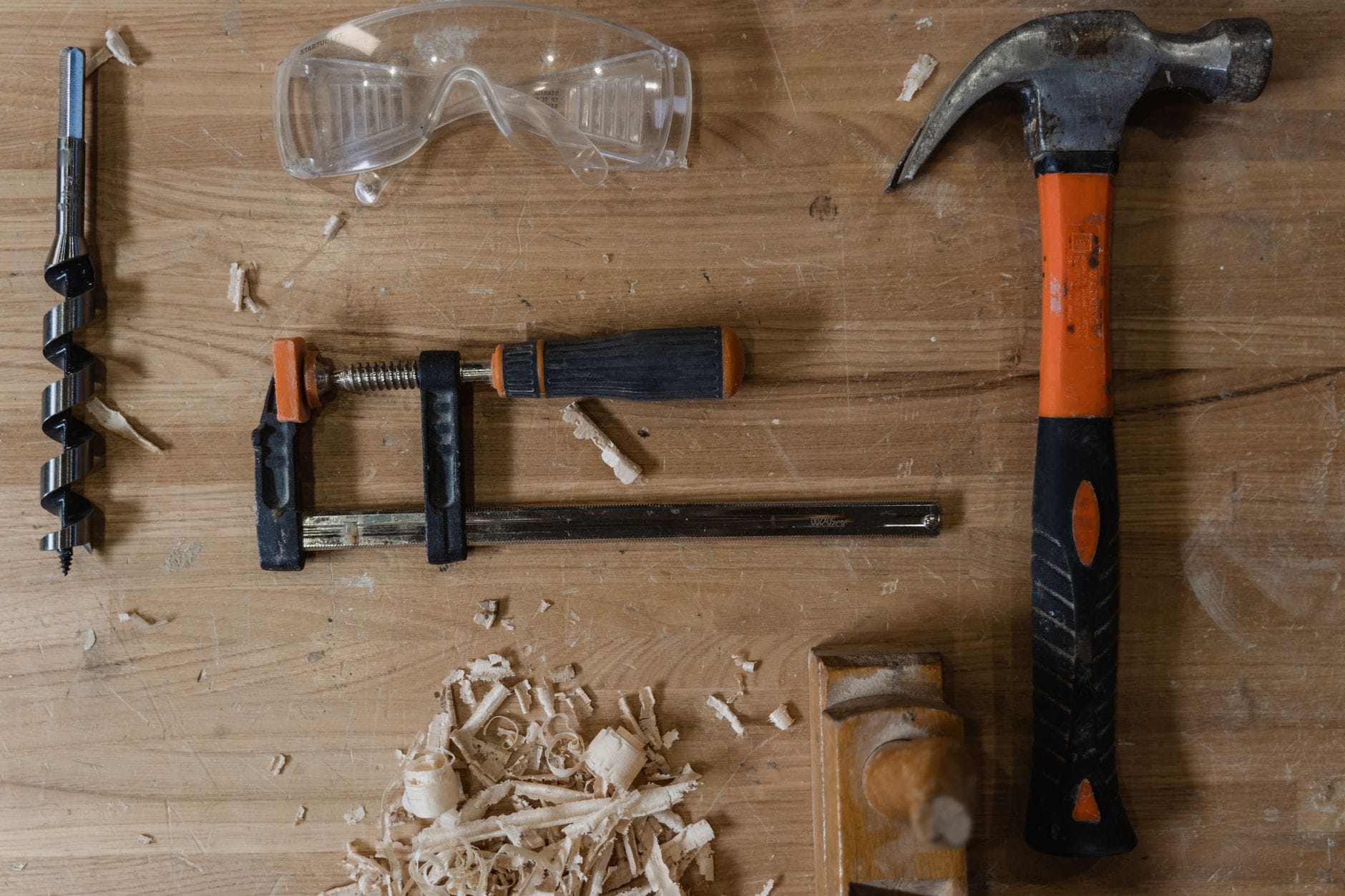 Flat lay of carpentry tools and wood shavings on a workbench. Ideal for DIY themes.